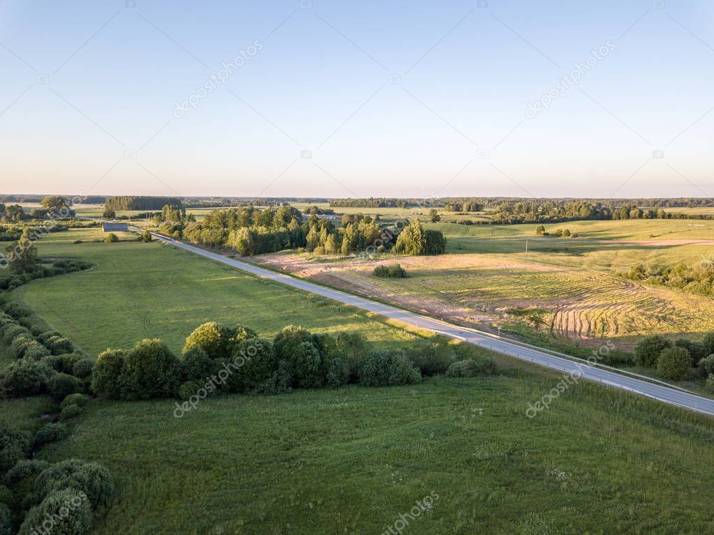 drone image. aerial view of countryside road network, cultivated fields and forest textures. latvia