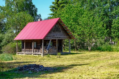 Eski ahşap Letonya kırsal kesimde yaz yeşillik ile binanın terk edilmiş kalıntıları