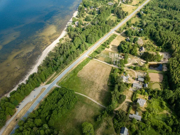 drone image. aerial view of Baltic sea shore with rocks and forest on land and highway near water. Latvia beach