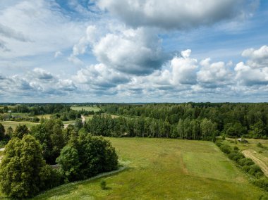 Drone görüntü. alanları ve bulutlu bahar günü ormanlarda kırsal alan hava görünümünü. Letonya