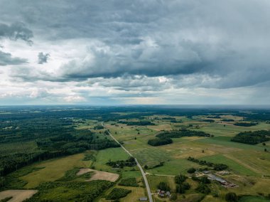 drone görüntü. havadan görünümü ve yaz günü bulutlarda şiddetli yağmur altında yollar ile kırsal alan. Letonya