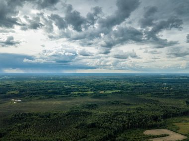drone görüntü. havadan görünümü ve yaz günü bulutlarda şiddetli yağmur altında yollar ile kırsal alan. Letonya
