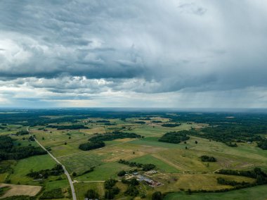 drone görüntü. havadan görünümü ve yaz günü bulutlarda şiddetli yağmur altında yollar ile kırsal alan. Letonya