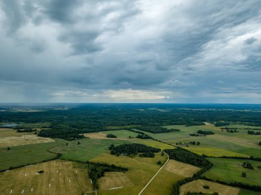 drone görüntü. havadan görünümü ve yaz günü bulutlarda şiddetli yağmur altında yollar ile kırsal alan. Letonya