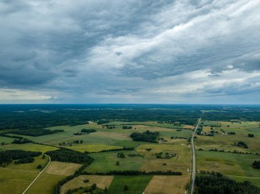 drone görüntü. havadan görünümü ve yaz günü bulutlarda şiddetli yağmur altında yollar ile kırsal alan. Letonya