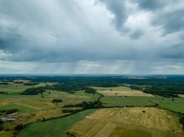 drone görüntü. havadan görünümü ve yaz günü bulutlarda şiddetli yağmur altında yollar ile kırsal alan. Letonya