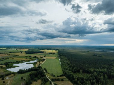 drone görüntü. havadan görünümü ve yaz günü bulutlarda şiddetli yağmur altında yollar ile kırsal alan. Letonya