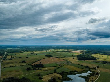 drone görüntü. havadan görünümü ve yaz günü bulutlarda şiddetli yağmur altında yollar ile kırsal alan. Letonya