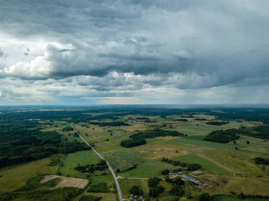 drone görüntü. havadan görünümü ve yaz günü bulutlarda şiddetli yağmur altında yollar ile kırsal alan. Letonya