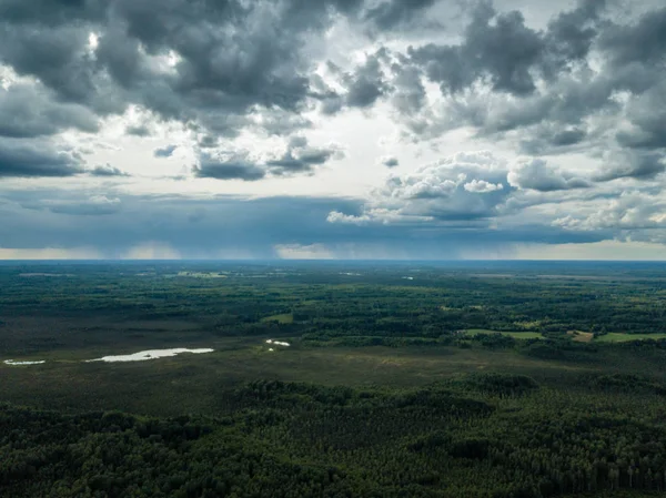 drone görüntü. havadan görünümü ve ağır ve karanlık dramatik yağmur bulutları yaz gün altında yollar ile kırsal alan. gece fotoğraf. Letonya