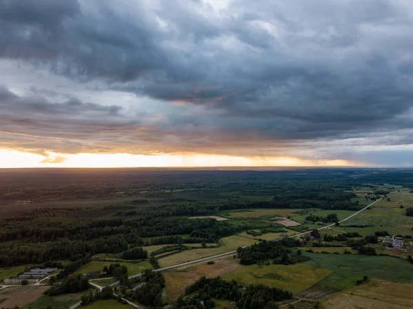 drone görüntü. havadan görünümü ve ağır ve karanlık dramatik yağmur bulutları yaz gün altında yollar ile kırsal alan. gece fotoğraf. Letonya