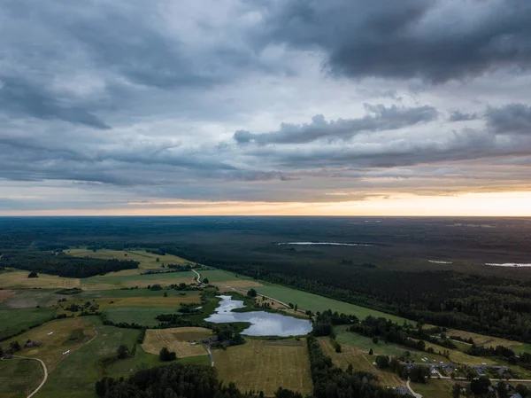 drone görüntü. havadan görünümü ve ağır ve karanlık dramatik yağmur bulutları yaz gün altında yollar ile kırsal alan. gece fotoğraf. Letonya
