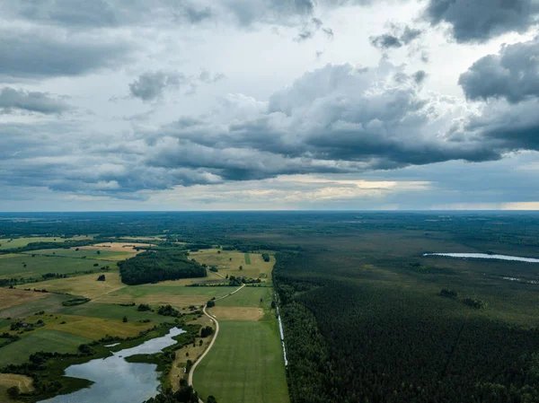 drone görüntü. havadan görünümü ve yaz günü bulutlarda şiddetli yağmur altında yollar ile kırsal alan. Letonya
