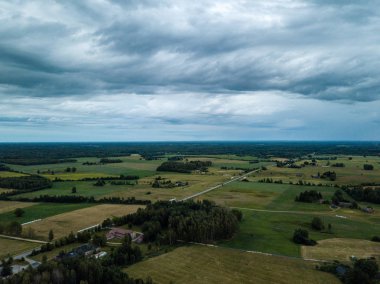 drone görüntü. havadan görünümü ve ağır ve karanlık dramatik yağmur bulutları yaz gün altında yollar ile kırsal alan. gece fotoğraf. Letonya