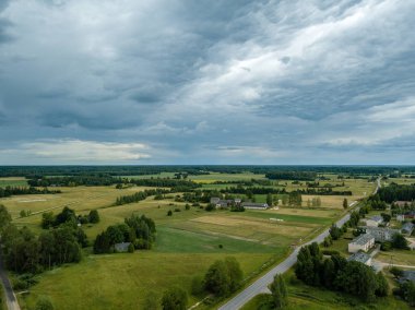 drone görüntü. havadan görünümü ve yaz günü bulutlarda şiddetli yağmur altında yollar ile kırsal alan. Letonya