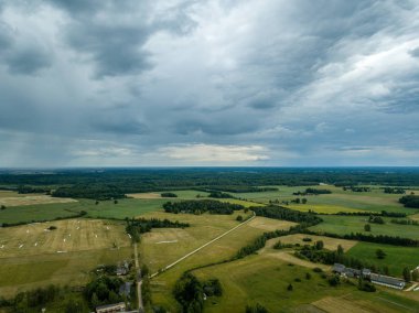 drone görüntü. havadan görünümü ve yaz günü bulutlarda şiddetli yağmur altında yollar ile kırsal alan. Letonya