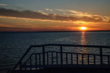 gemi halatları ve metal korkuluk ile Baltık Denizi üzerinde dramatik kırmızı gündoğumu