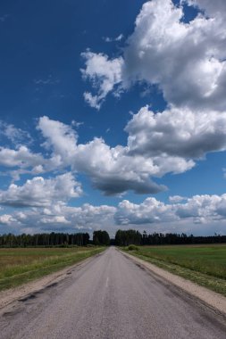 Yaz aylarında köy çakıl yol kırsal etrafında ağaçlar ve bulutlar gökyüzünde