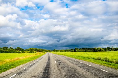 Yaz aylarında köy çakıl yol kırsal etrafında ağaçlar ve bulutlar gökyüzünde