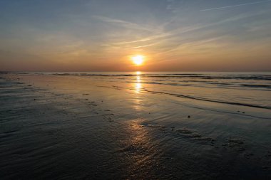 Güzel günbatımı yoğun bulutlar ve küçük dalgalar ile Baltık Denizi