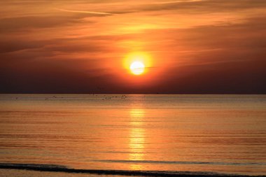 Güzel günbatımı yoğun bulutlar ve küçük dalgalar ile Baltık Denizi