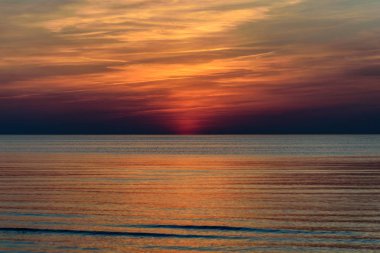 Güzel günbatımı yoğun bulutlar ve küçük dalgalar ile Baltık Denizi