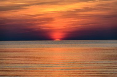 Güzel günbatımı yoğun bulutlar ve küçük dalgalar ile Baltık Denizi