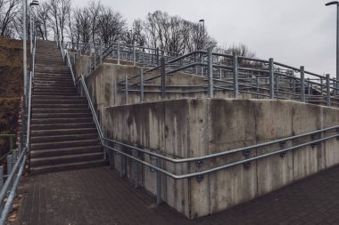 parlak Ray ve somut adımlar ile yeni metal köprü. bulutlu bahar günü