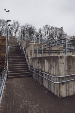 parlak Ray ve somut adımlar ile yeni metal köprü. bulutlu bahar günü