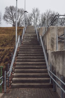 parlak Ray ve somut adımlar ile yeni metal köprü. bulutlu bahar günü