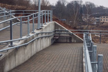 parlak Ray ve somut adımlar ile yeni metal köprü. bulutlu bahar günü