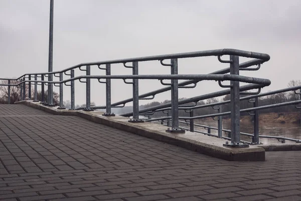 崭新的金属桥 有闪亮的铁轨和具体的台阶 多云春季日 — 图库照片