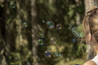 Genç kadının doğal yollar orman içinde. Vintage bir görünüm. sabun köpüğü üfleme