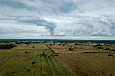 drone görüntü. kırsal alan alanları ve ormanlar dramatik fırtına bulutları oluşturan altında hava görünümünü. yaz günü Letonya