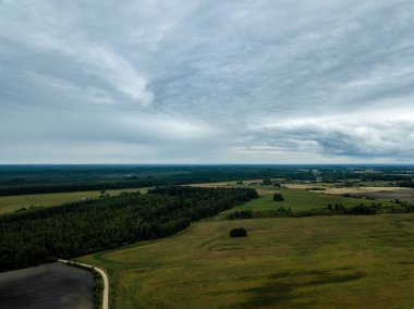 drone görüntü. kırsal alan alanları ve ormanlar dramatik fırtına bulutları oluşturan altında hava görünümünü. yaz günü Letonya