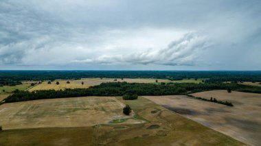 drone görüntü. kırsal alan alanları ve ormanlar dramatik fırtına bulutları oluşturan altında hava görünümünü. yaz günü Letonya
