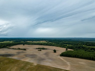 drone görüntü. kırsal alan alanları ve ormanlar dramatik fırtına bulutları oluşturan altında hava görünümünü. yaz günü Letonya