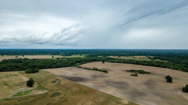 drone görüntü. kırsal alan alanları ve ormanlar dramatik fırtına bulutları oluşturan altında hava görünümünü. yaz günü Letonya