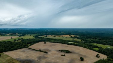 drone görüntü. kırsal alan alanları ve ormanlar dramatik fırtına bulutları oluşturan altında hava görünümünü. yaz günü Letonya