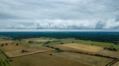 drone görüntü. kırsal alan alanları ve ormanlar dramatik fırtına bulutları oluşturan altında hava görünümünü. yaz günü Letonya