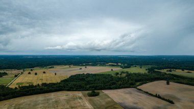 drone görüntü. kırsal alan alanları ve ormanlar dramatik fırtına bulutları oluşturan altında hava görünümünü. yaz günü Letonya