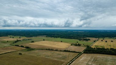 drone görüntü. kırsal alan alanları ve ormanlar dramatik fırtına bulutları oluşturan altında hava görünümünü. yaz günü Letonya