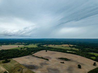 drone görüntü. kırsal alan alanları ve ormanlar dramatik fırtına bulutları oluşturan altında hava görünümünü. yaz günü Letonya