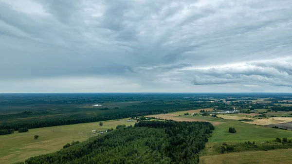 drone görüntü. kırsal alan alanları ve ormanlar dramatik fırtına bulutları oluşturan altında hava görünümünü. yaz günü Letonya