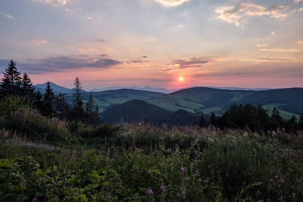 beautiful sunset in the mountains of Tatra, slovakia. hill tops with red clouds over them.  Western carpathian