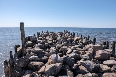 Baltık seawith mavi gökyüzü ve sakin su eski taş brakewater