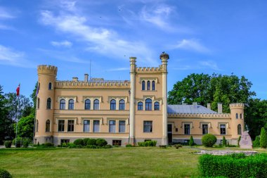 Vintage sarı tuğla manor çiçeklerle, önünde güzel yaz günü mavi gökyüzü ile kırsal kesimde