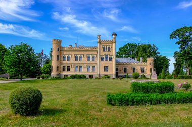 Vintage sarı tuğla manor çiçeklerle, önünde güzel yaz günü mavi gökyüzü ile kırsal kesimde