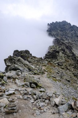 bulutlar ve sis yukarıdan ve yağmur bulutları ile keskin kayalık dağ başında Slovakya'daki Tatra Dağları'nda. Rysy dağın.