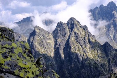 bulutlar ve sis yukarıdan ve yağmur bulutları ile keskin kayalık dağ başında Slovakya'daki Tatra Dağları'nda. Rysy dağın.